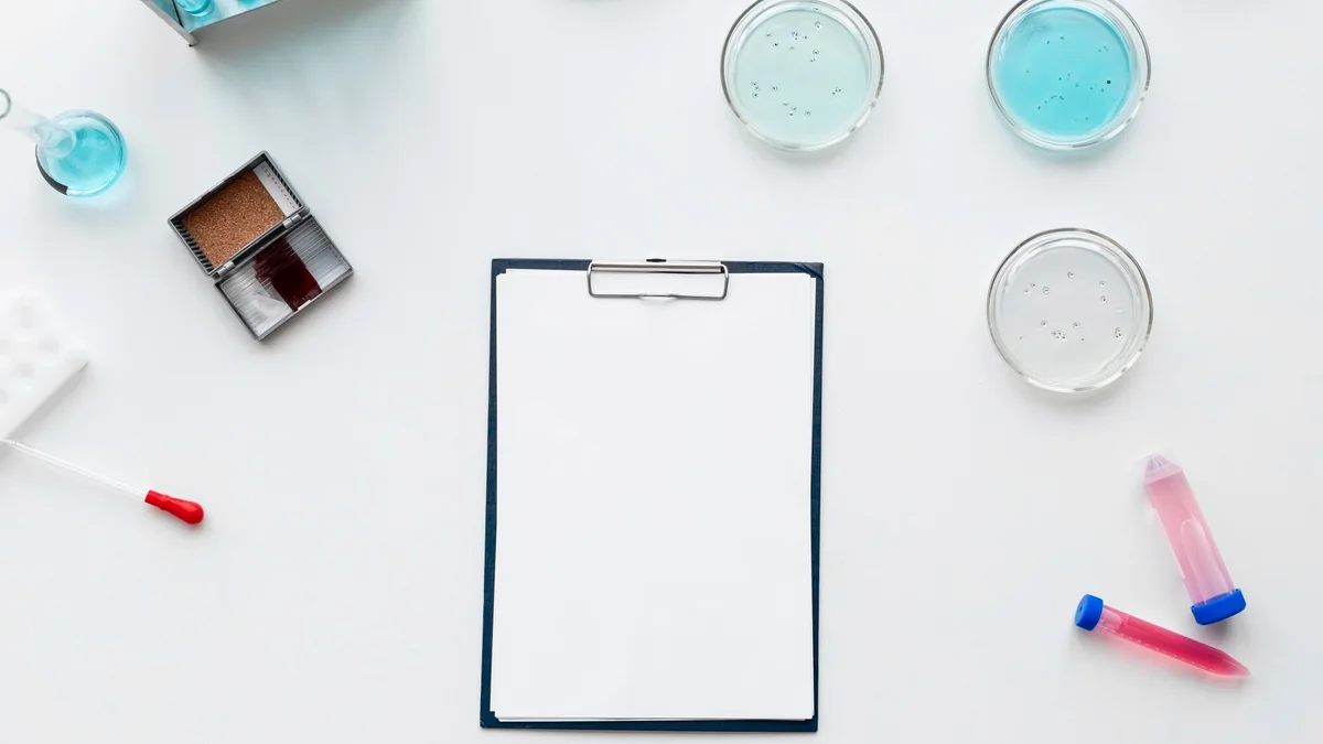 Blank laboratory clipboard surrounded by analytical equipment and samples.