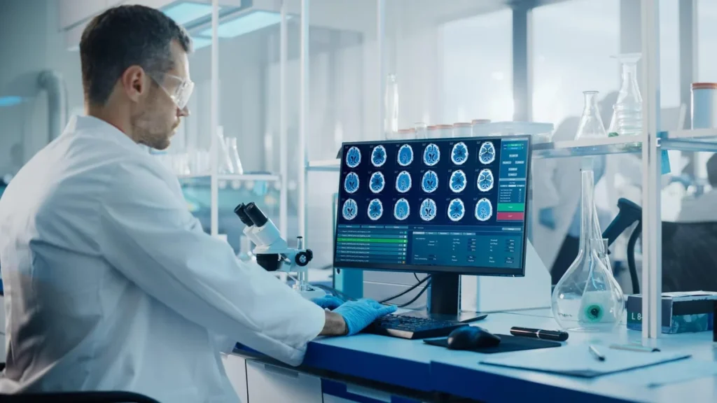 Neuroscience researcher reviewing brain images on a laboratory workstation.