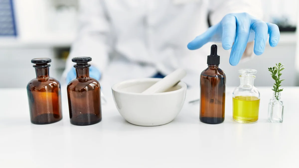 Compounding workspace with mortar, amber bottles, and laboratory glassware.