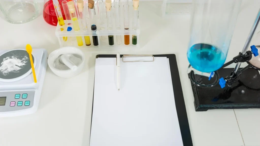 Laboratory report clipboard surrounded by test tubes and analytical equipment.