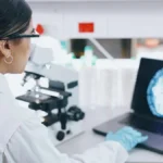 Neuroscience researcher reviewing microscopy and brain-imaging data.