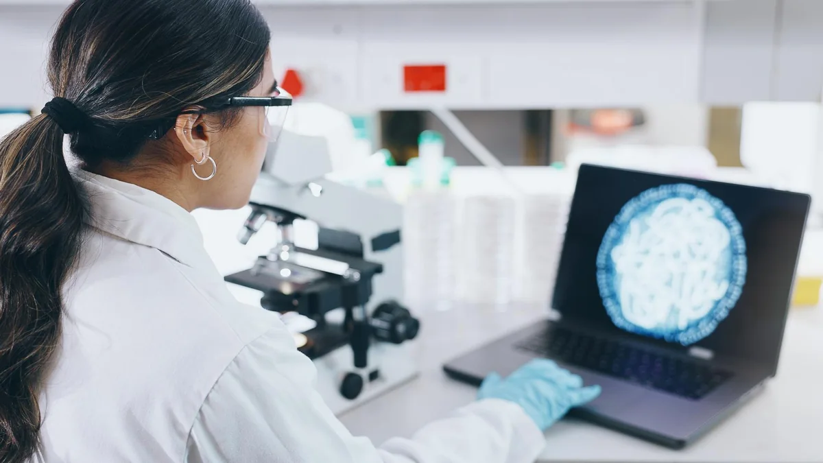 Neuroscience researcher reviewing microscopy and brain-imaging data.