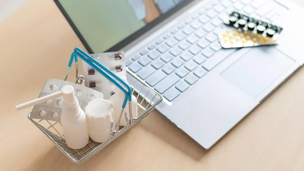 Medication packages beside a laptop, illustrating clinician-guided treatment comparisons.